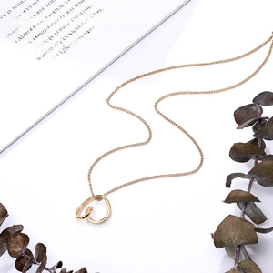 Detailed view of intertwined irregular gold circles on a minimalist steel necklace