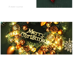 Close-up of Christmas wreath with warm LED lights, pine cones, and Merry Christmas sign