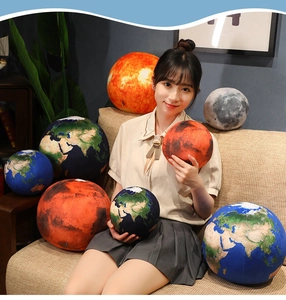 Detailed view of spherical planet plush pillows including Earth and Moon in a home setting