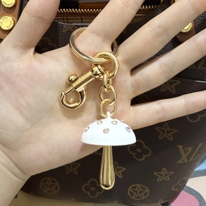 Detail van paddenstoel sleutelhanger met gekleurde kristallen en goud metaal