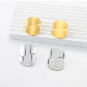 Detailed view of irregular 18K gold and silver plated stainless steel earrings on a pedestal