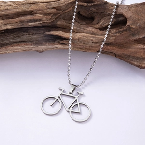 Polished stainless steel mountain bike pendant necklace on rustic wood background