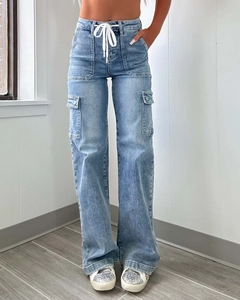 Detail view of light blue cargo denim jeans featuring large side pockets and drawstring waist