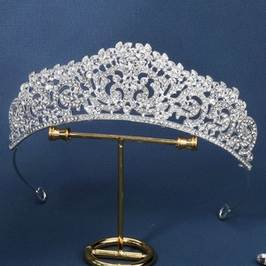 Luxurious silver bridal tiara with sparkling rhinestones on a golden display stand