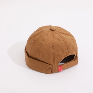 Detail view of the adjustable back strap and red brand tag on the brown cotton docker hat
