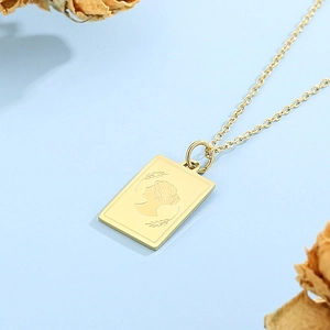 Macro view of gold rectangular zodiac pendant with vintage embossed female silhouette