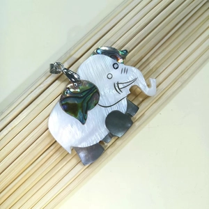 Detail of elephant pendant with white shell body and iridescent abalone shell inlay