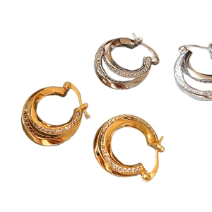 Double-layered twisted geometric hoop earrings with sparkling pavé crystals in gold and silver