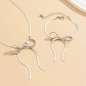 Detailed shot of silver bow tie necklace and bracelet set with flat snake chain links