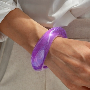 Detail of purple resin bangle with sparkling glitter flakes on a model's wrist
