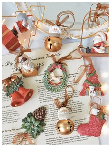 Flat lay of vintage Christmas ornaments set with Santas, bells, and trees on poem paper