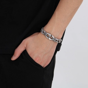 Detailed close-up of retro silver stainless steel bracelet with embossed totem texture