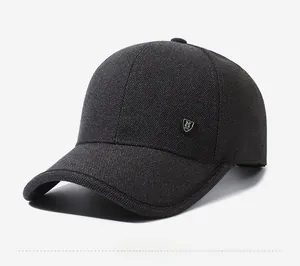 Side view detail of dark gray textured baseball cap with a silver M logo badge