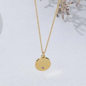 Minimalist gold stainless steel round pendant necklace with small inlaid diamond detail