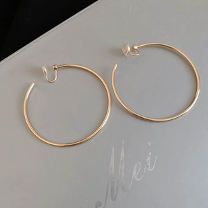Macro view of gold-plated hoop earrings with transparent clip-on silicone pads