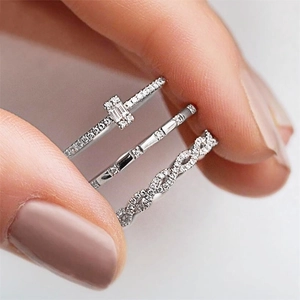 Macro detail of silver zircon stacking rings featuring a twisted band and rectangular stones