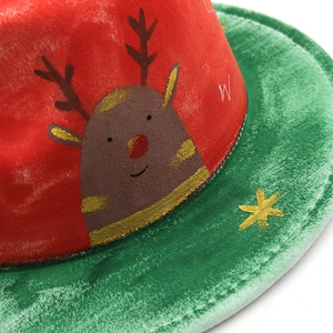 Détail d'un chapeau de Noël en feutre rouge et vert avec renne et étoiles dorées