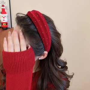 Detail view of red velvet headband with silver beaded accents worn by a model