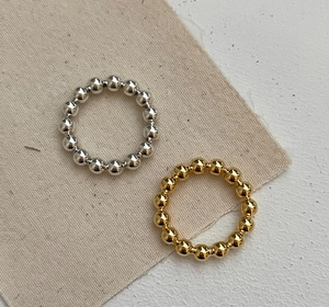Macro detail of minimalist 925 sterling silver beaded rings in gold and silver finishes