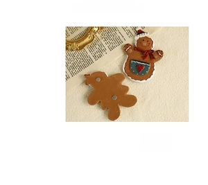 Detail of gingerbread man resin magnet showing front design and back magnetic attachment