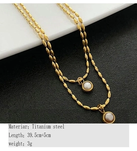 Macro shot of titanium steel layered necklace with two white pearl pendants in gold finish