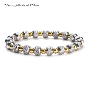 Detail of 7mm two-tone gold and silver beaded elastic bracelet with diamond-cut texture