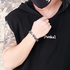 Macro detail of industrial punk steel bracelet with S-shaped hollow links on male wrist