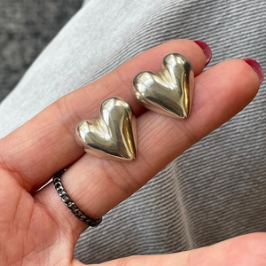 Close-up of polished 925 sterling silver heart earrings with high mirror finish