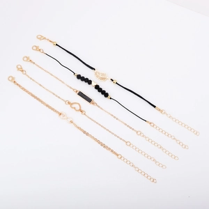 Detail of 5-piece bracelet set featuring gold leaves, hearts, and black beaded strands