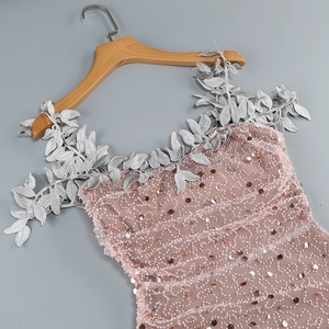 Detail of pink sequined gown featuring silver leaf embroidery on the elegant neckline