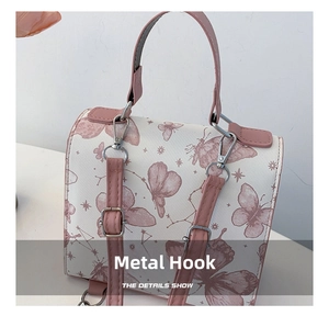 Detail of silver hardware hook and pink shoulder strap connection on butterfly bag