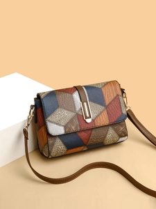Detailed close-up of multi-color leather patchwork and golden buckle on crossbody bag