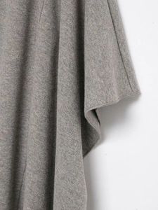 Gros plan sur la maille fine grise montrant la texture douce et le drapé élégant du tissu