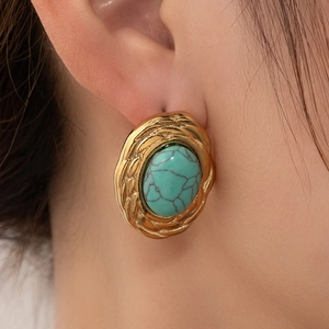 Boucles d'oreilles ovales en turquoise plaqué or 18 carats avec texture tissée sur modèle