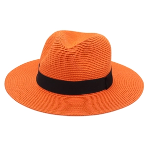Detailed weave texture of vibrant orange Panama hat with a black grosgrain ribbon