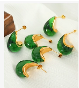Detailed view of 18K gold plated teardrop earrings with emerald green resin stones