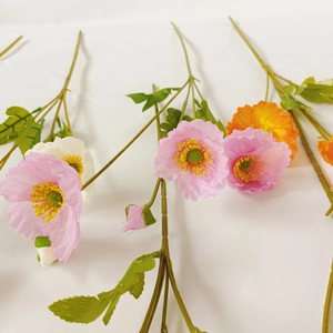 Detailed view of colorful artificial poppy flowers in pink, white, and orange hues