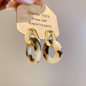 Detail of leopard print resin hoops with gold hammered metal pieces and 100% copper card