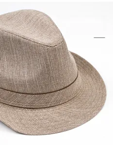 Close-up of the woven texture and dark brown ribbon on a stylish summer fedora hat