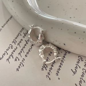 Close-up of 925 sterling silver croissant hoop earrings on ceramic tray with S925 hallmark