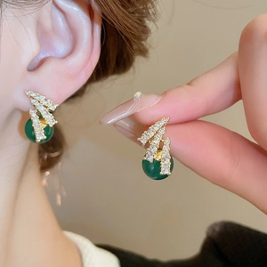 Eleganti orecchini a perno dorati con perle di resina verde e zirconi a zucca