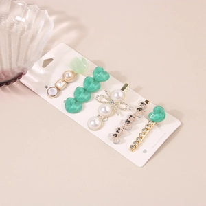 Détail d'un lot de 5 pinces à cheveux avec perles, strass et formes de cœur sur métal doré