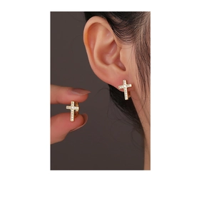 Close-up of 14K gold-plated cross hoop earrings featuring shimmering pave zircon accents