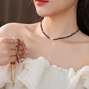 Detailed shot of titanium steel pearl necklace with colorful gemstone beaded bracelets