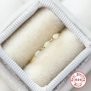 Macro shot of gold S925 silver ring with marquise opals in a white velvet jewelry box