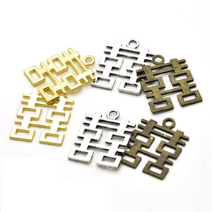 Macro shot of vintage alloy Double Happiness pendants in gold silver and bronze