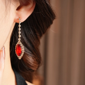 Close-up of red water-drop rhinestone tassel earring worn on model for luxury party wear
