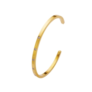Detailed close-up of C-shaped 18k gold plated bangle with inlaid round zircon stones