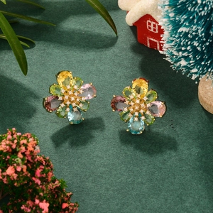 Macro shot of colorful zircon flower earrings in gold finish with holiday decor