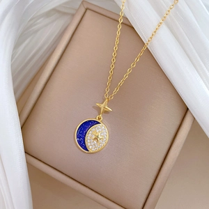 Detailed close-up of a luxury celestial star and moon pendant necklace with blue enamel